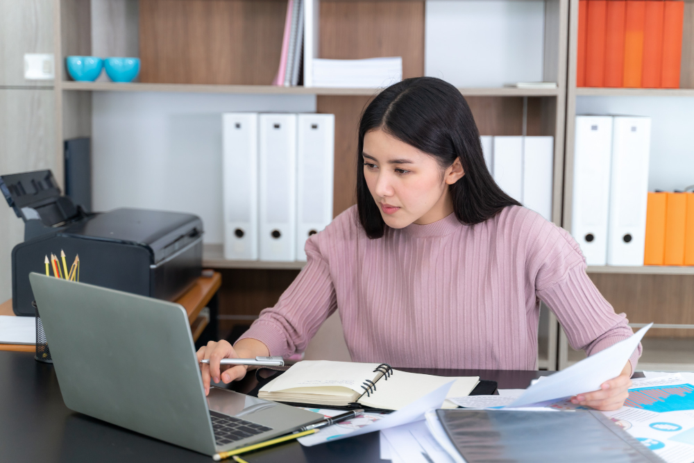 Focused administrative assistant managing communications and office operations using digital tools.