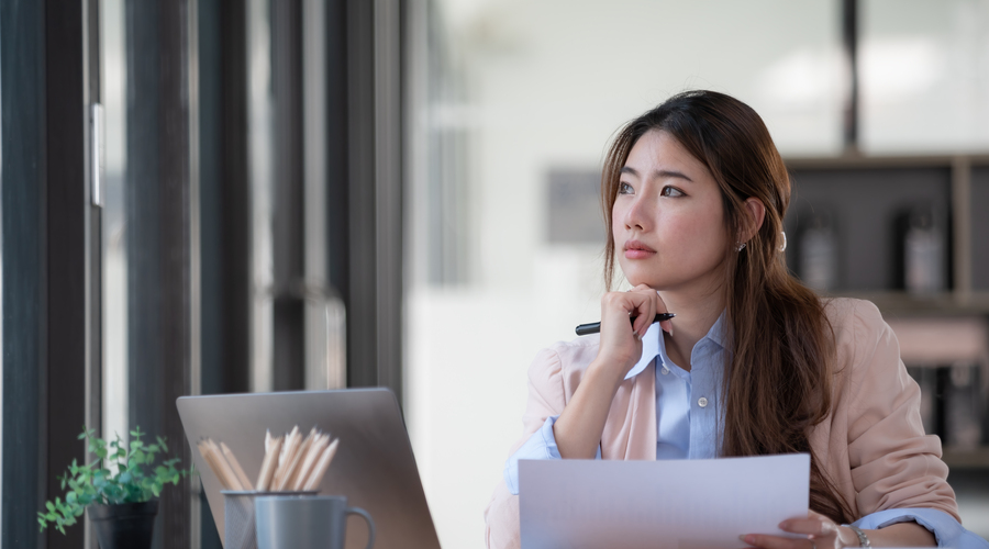 Asian office worker annoyed and stressed because of her work