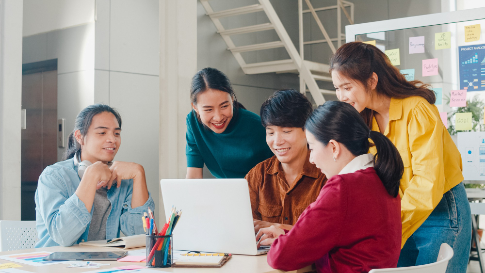 Nhóm bạn trẻ Gen Z cùng nhau thảo luận kế hoạch tại văn phòng hiện đại, minh họa cho cách làm việc hiệu quả thông qua tinh thần hợp tác và sáng tạo. 