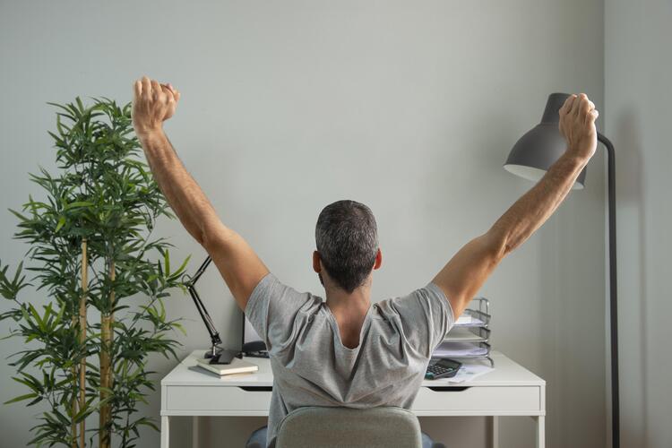 Back View Man Stretching His Arms While Working From Home