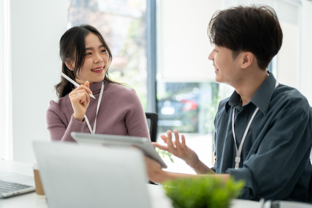 Two colleagues discussing a solution to a work-related problem, demonstrating good communication in the workplace through direct interaction.