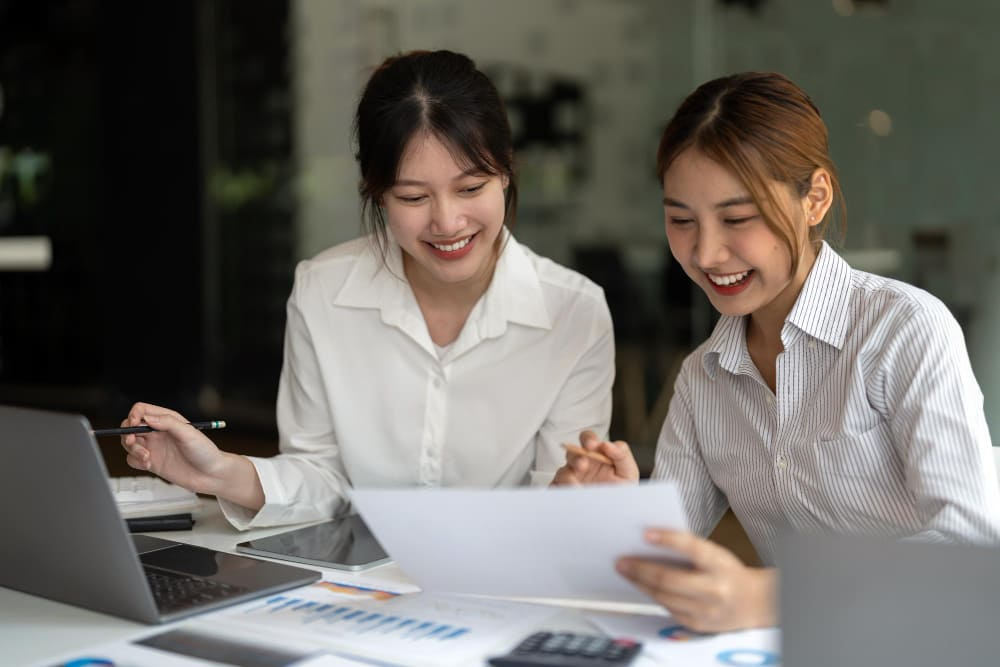 2 workers discussing payroll services in office setting