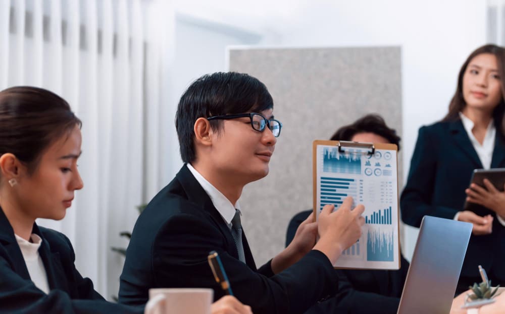 Team of professional discussing Payroll Services with graphs