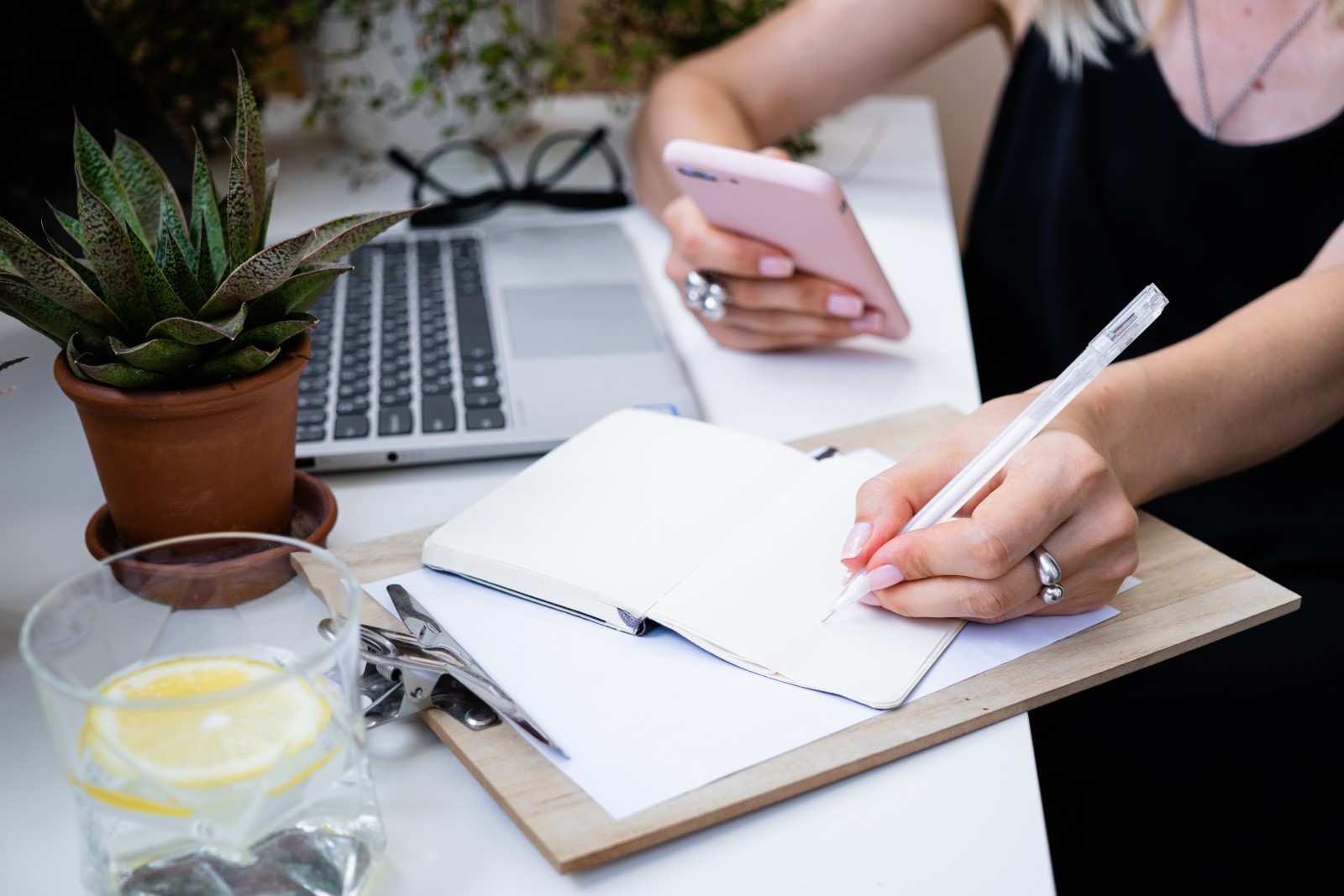 Office worker writing down a to-do list to survive corporate chaos