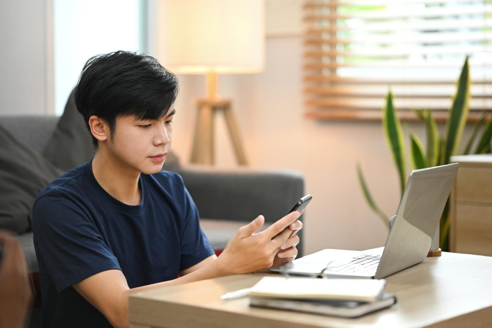 Young man reviewing a confirm meeting appointment email on his phone before sending