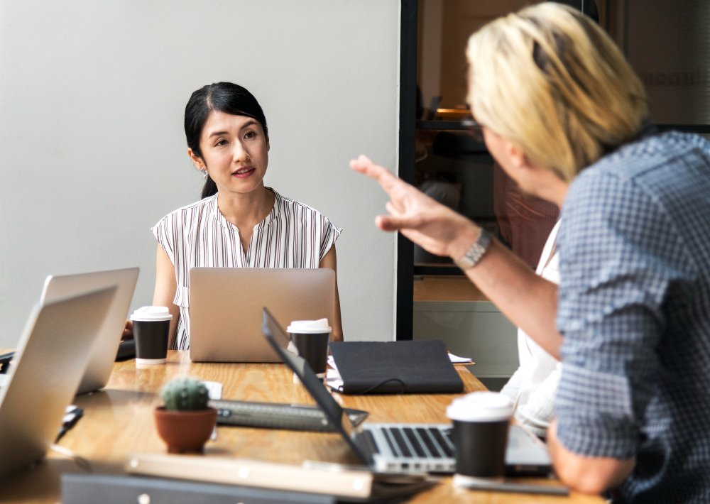 A young woman actively listening during a business meeting, showing engagement and good communication in the workplace.