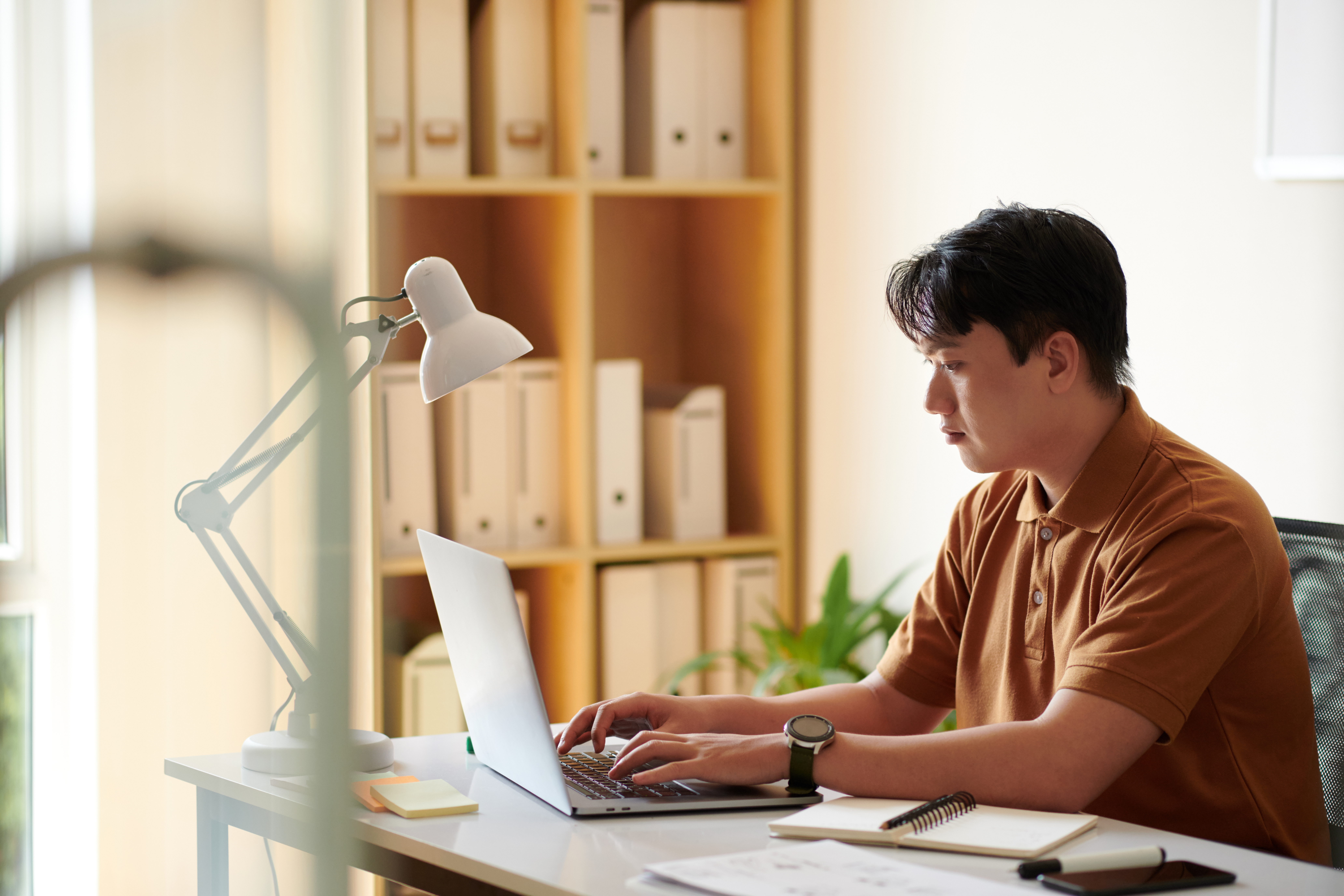 A man creating a productive home office setup, perfect for maintaining focus in work from home jobs.