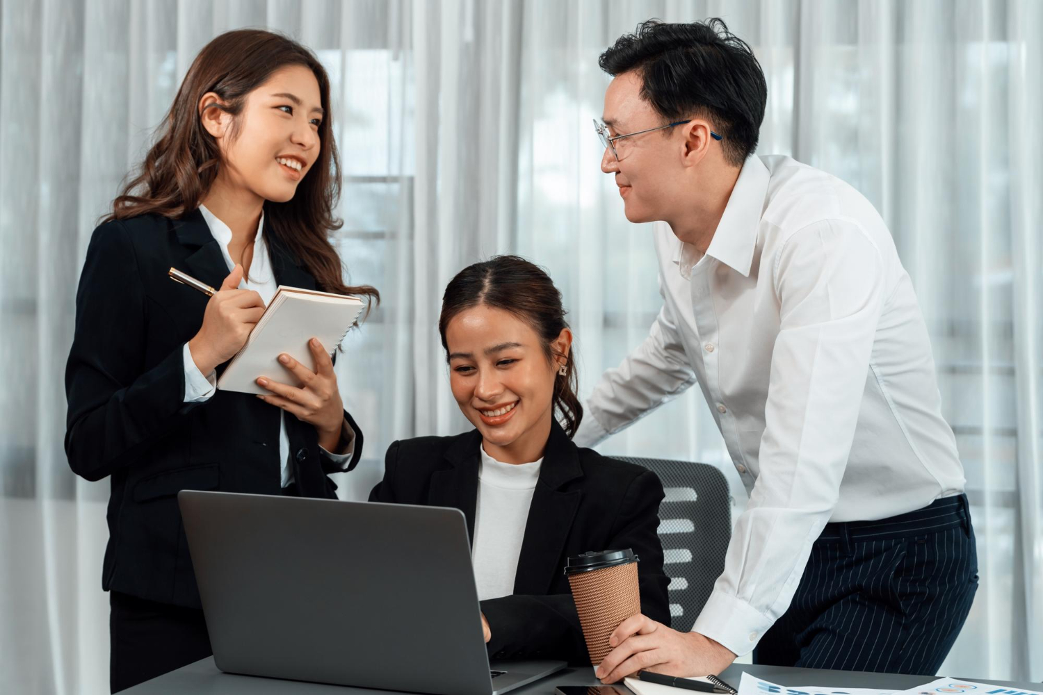 2 đồng nghiệp đang vui vẻ hỗ trợ nhân viên mới tại văn phòng làm việc