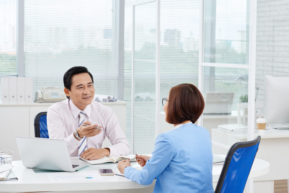 HR recruiter consulting with a medical clinician in a modern office.