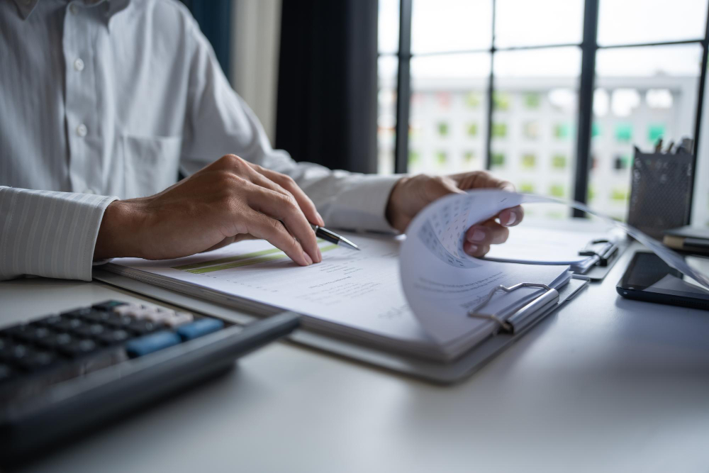 Professional reviewing business data and using calculator