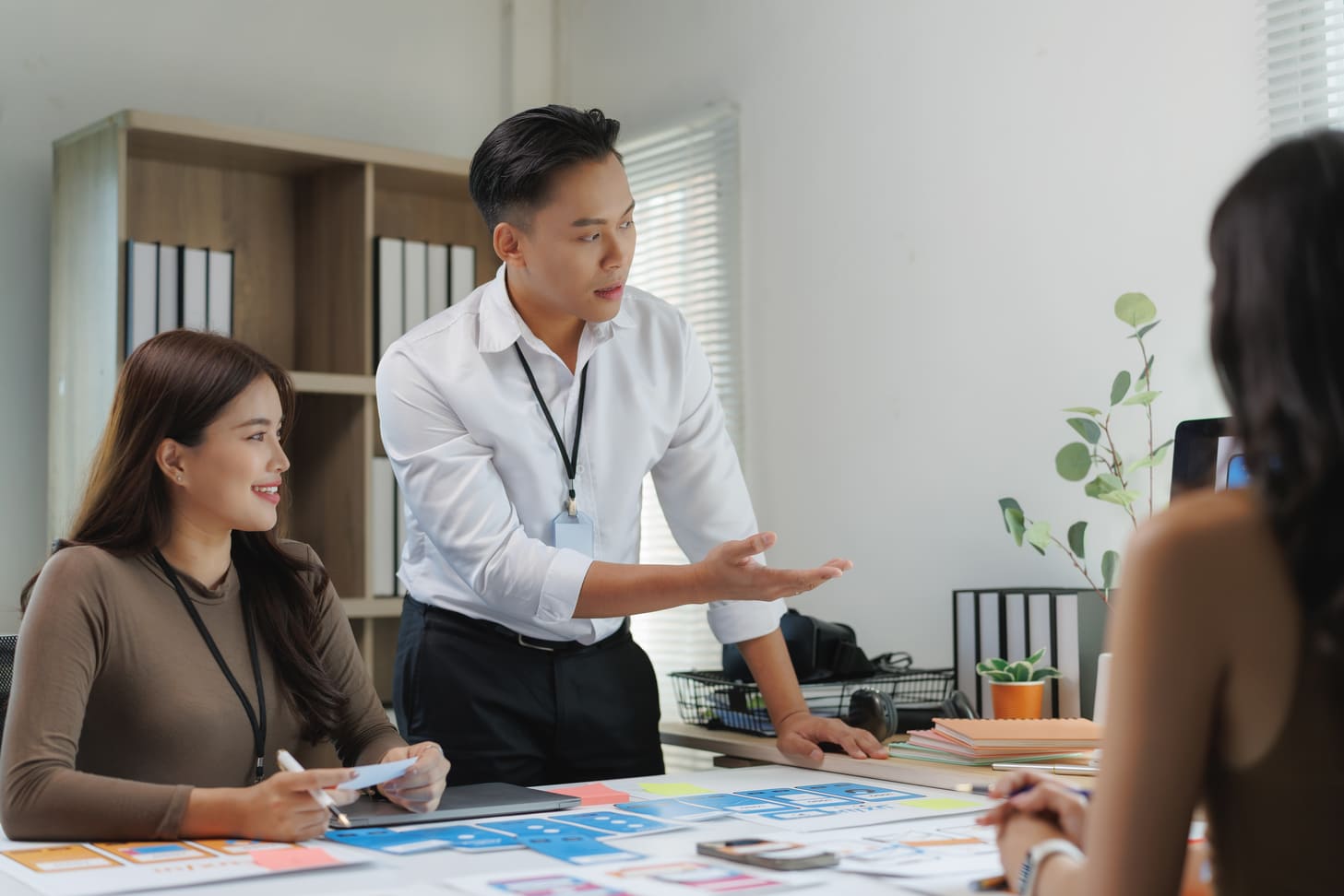 Team leader explaining organizational changes to office employees in a meeting room