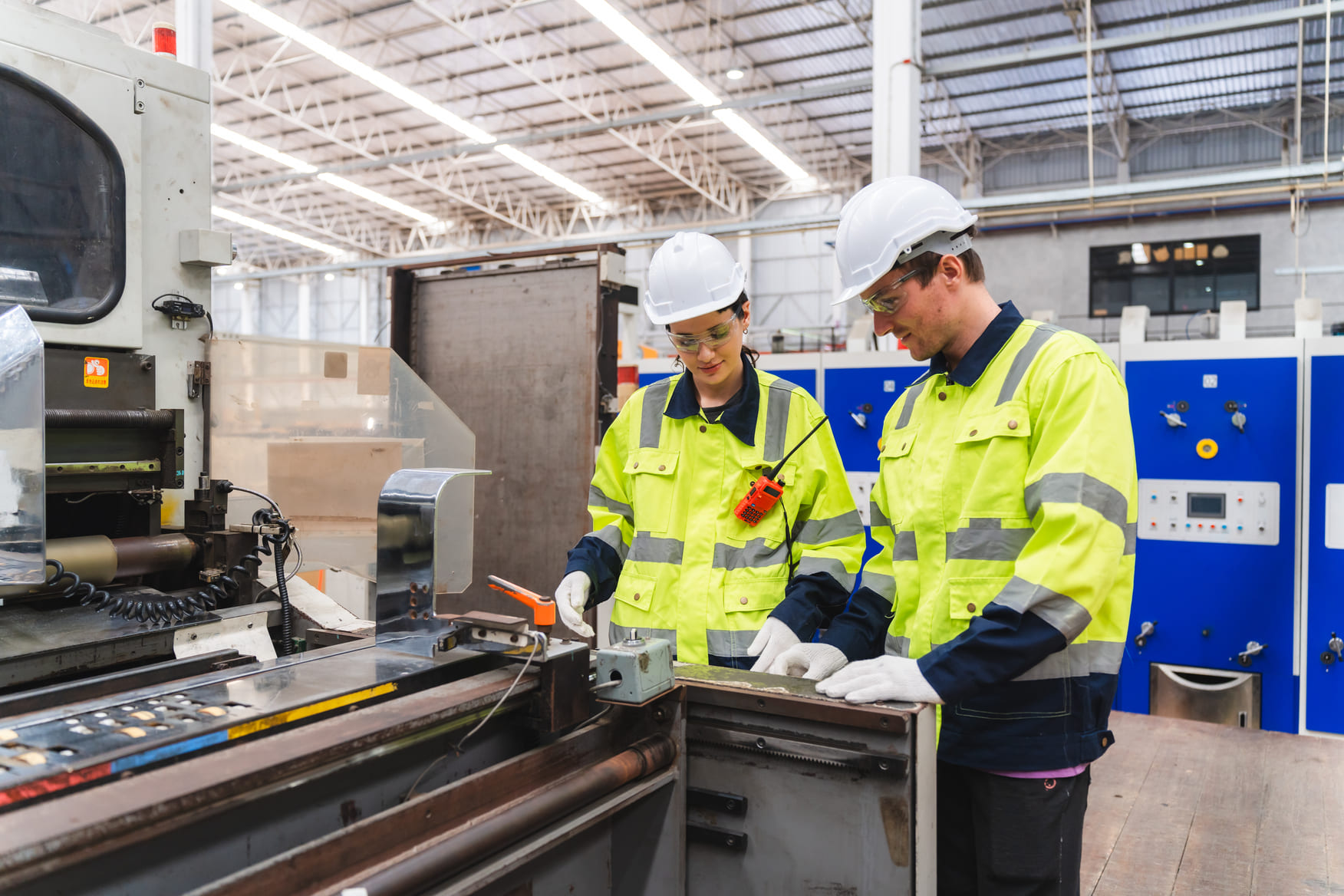 Industrial workers inspect machinery in factory