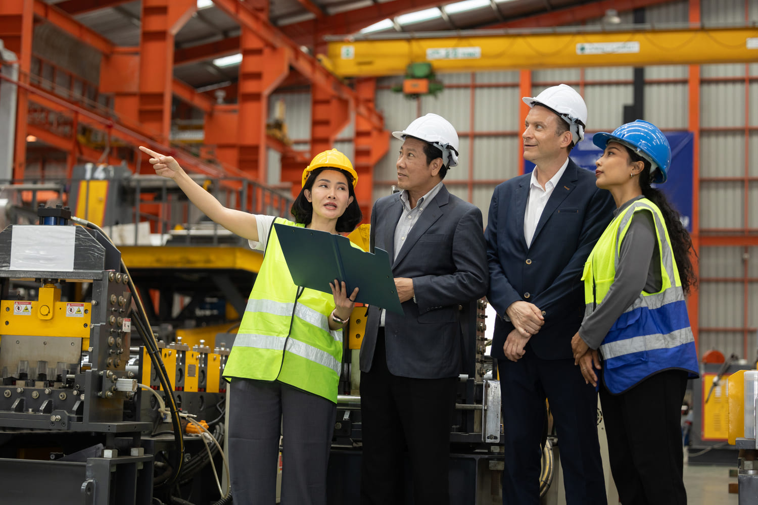 Industrial tech engineers and manufacturing leaders discussing operational expansion inside a factory.