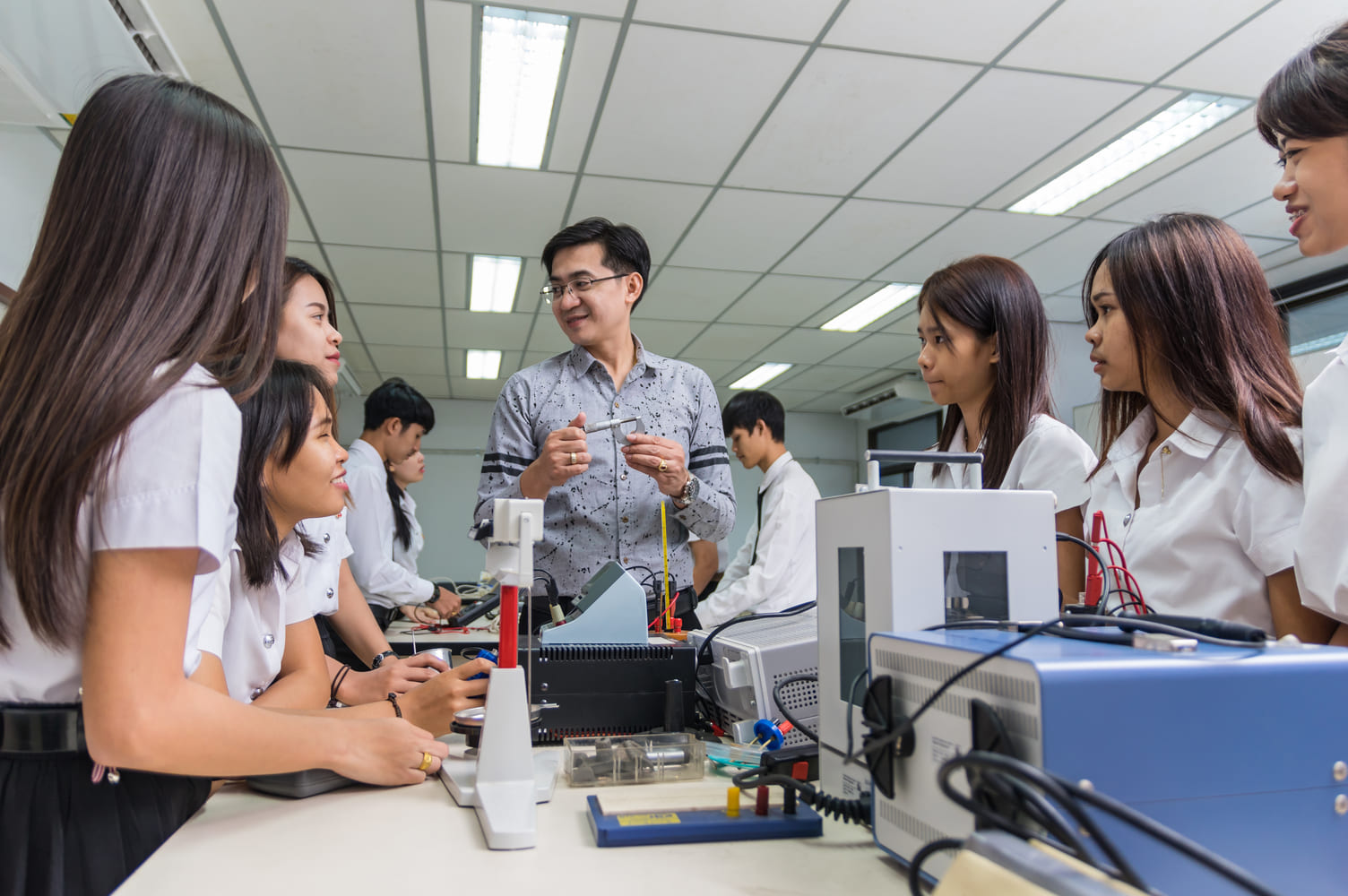 Manufacturing supervisor conducting a shift briefing with electronics assembly workers