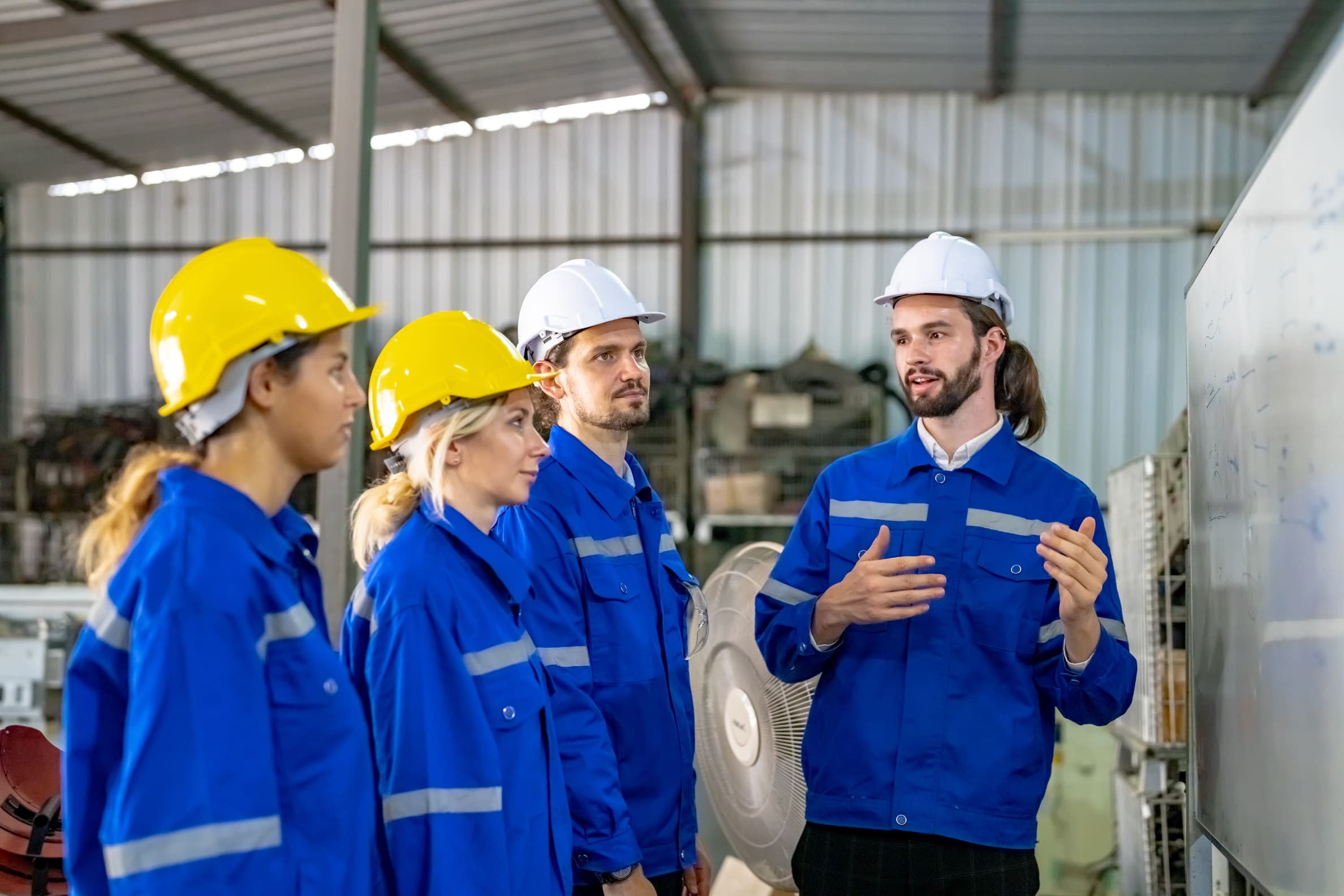 Newly hired factory workers in uniform completing safety orientation and intake training