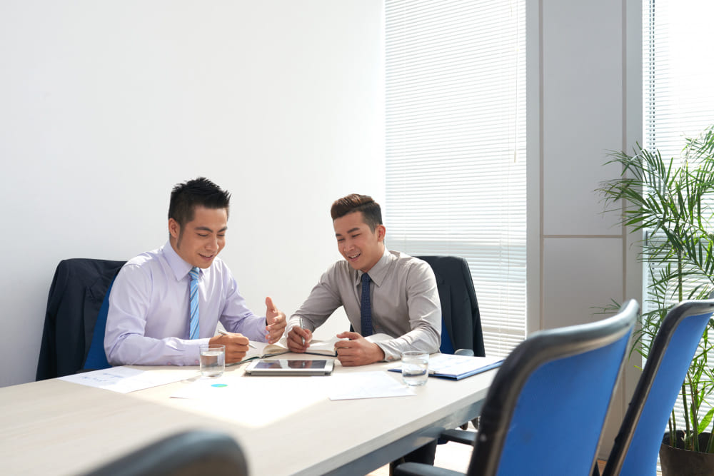 Manager and employee conducting a one-on-one workplace discussion in a modern office meeting room