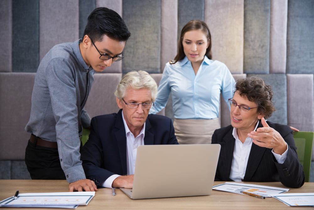 Cross-functional leadership team discussing strategic workforce management in a board room