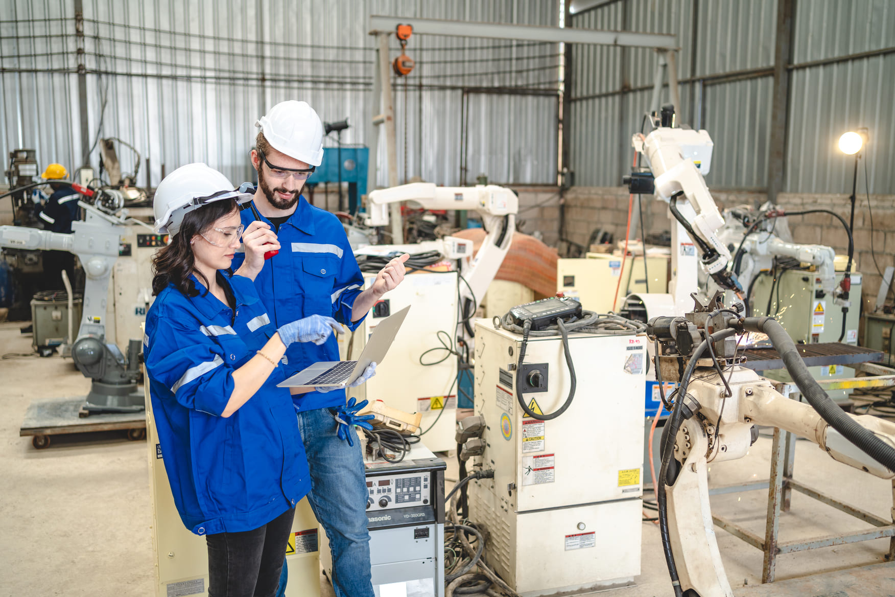 Senior automation engineer mentoring a junior technician on industrial machine setup
