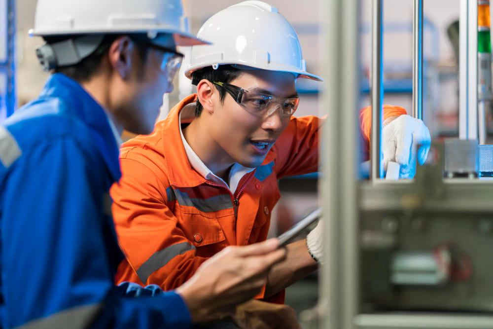 Factory supervisor inspecting operators on a high-priority manufacturing assembly line