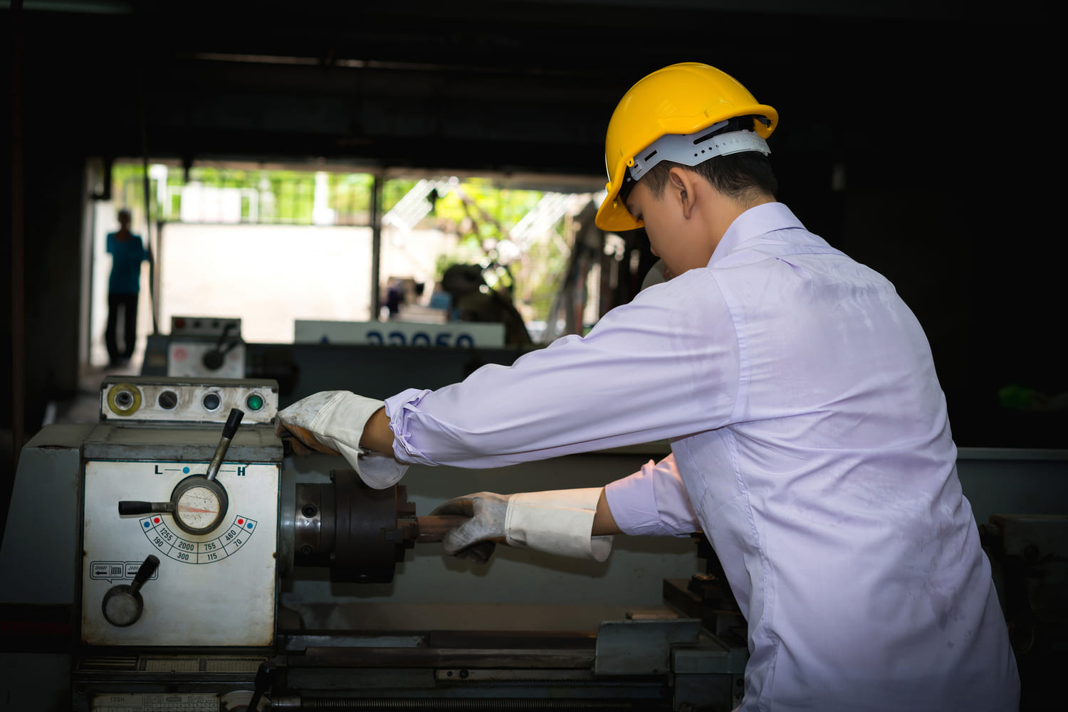 Experienced returning technician operating and adjusting automated manufacturing machinery