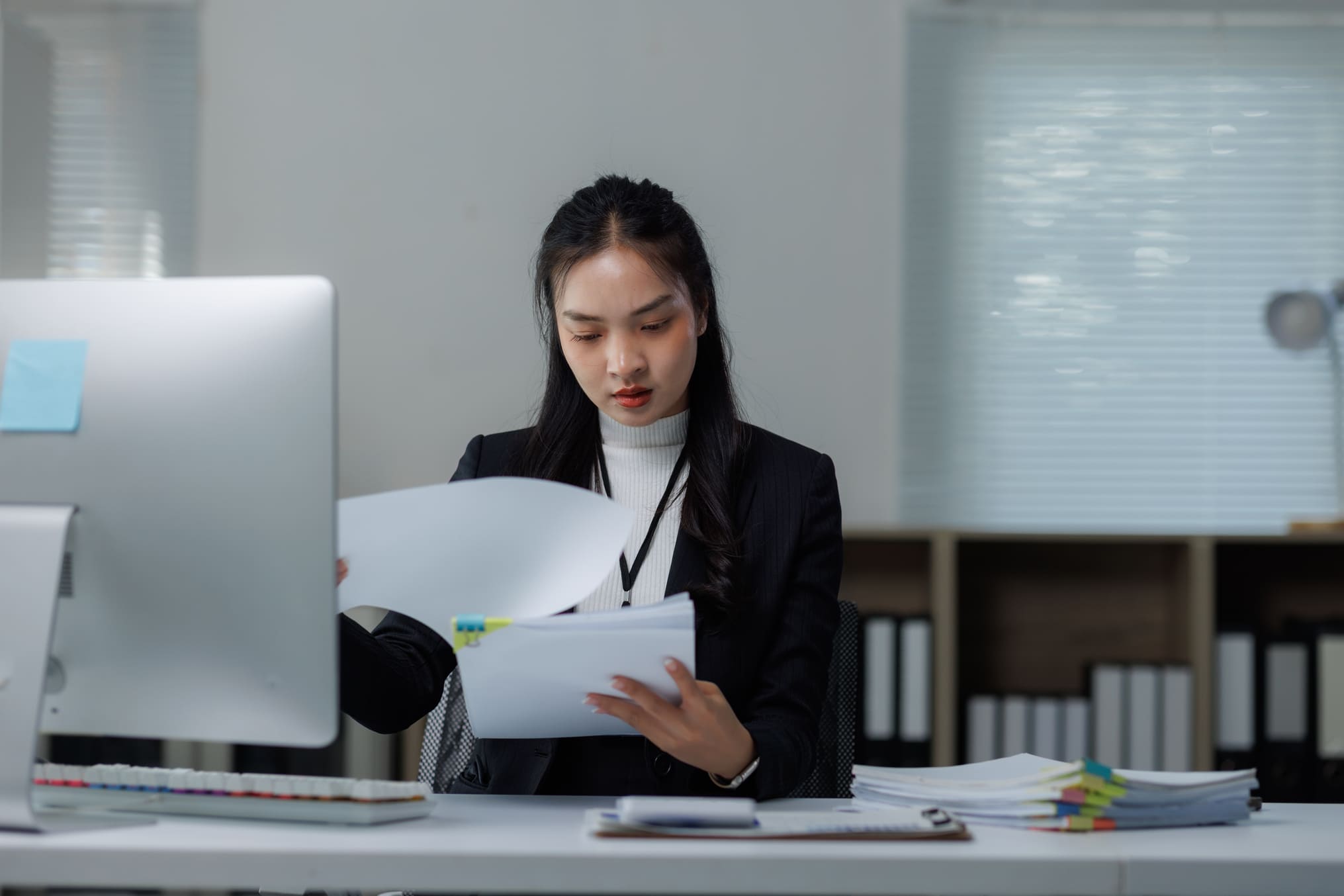 HR manager reviewing employee records and compliance documentation at office desk