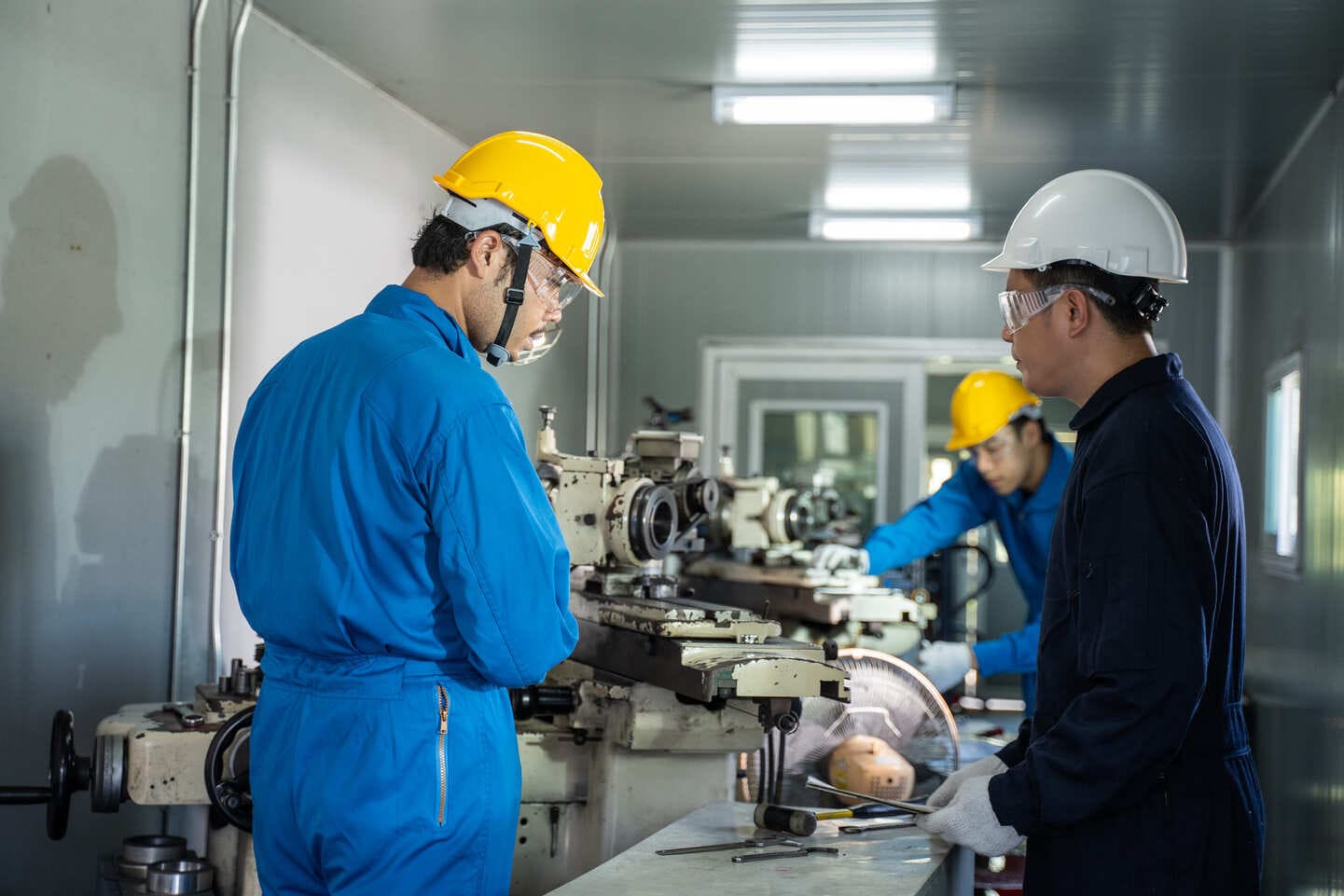 Senior technician training a junior operator on precision manufacturing equipment