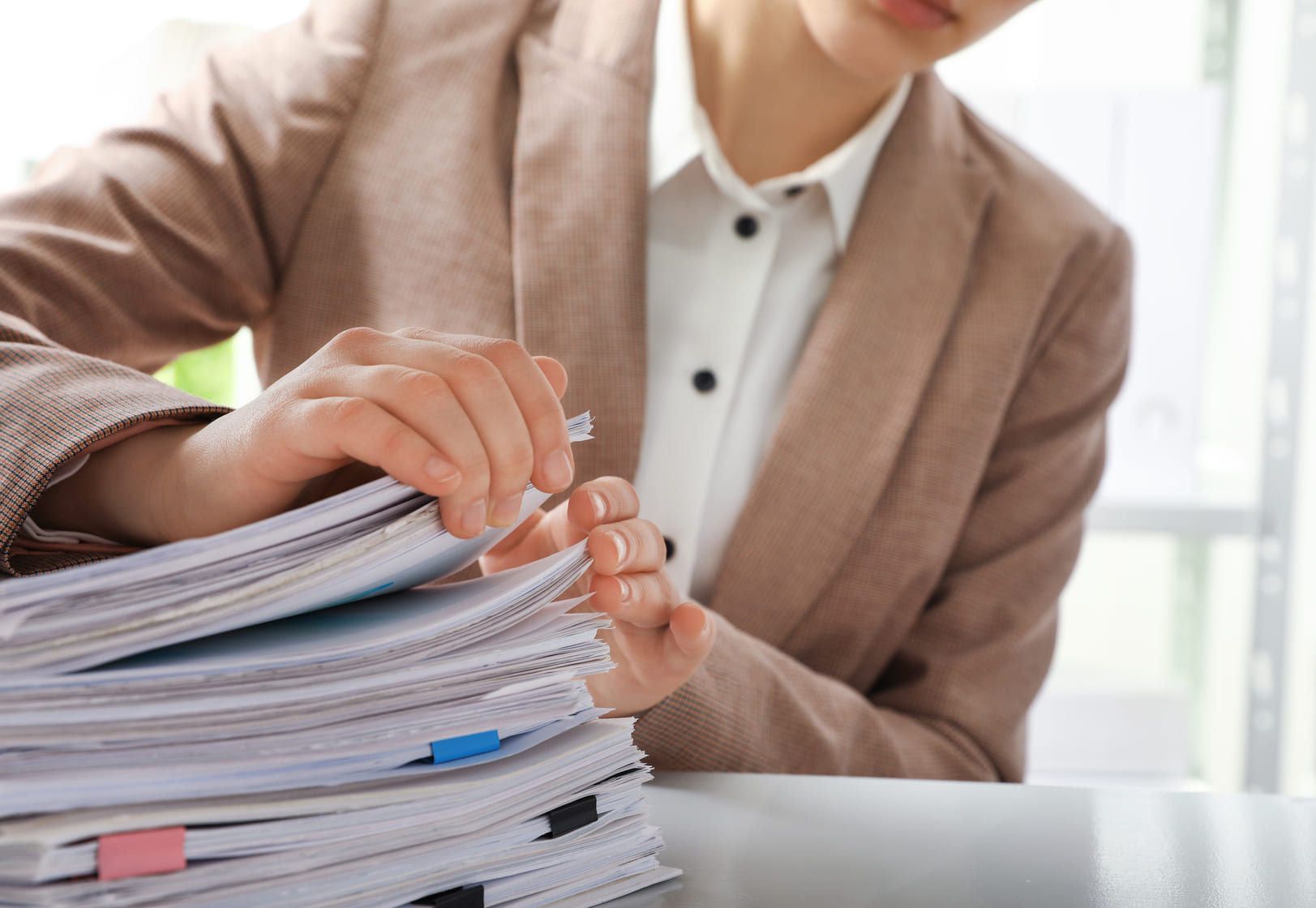 Administrative professional organizing employee labor contracts and compliance regulation files
