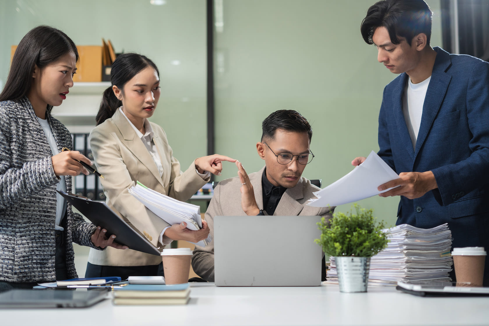 Business leaders and HR managers reviewing workplace compliance policies around a conference table
