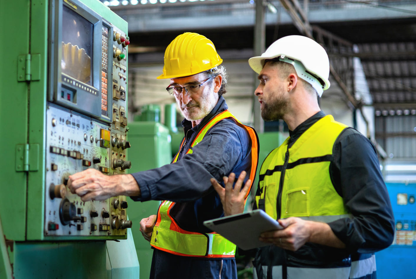 Industrial engineer guiding a colleague through hands-on technical problem-solving on the shop floor