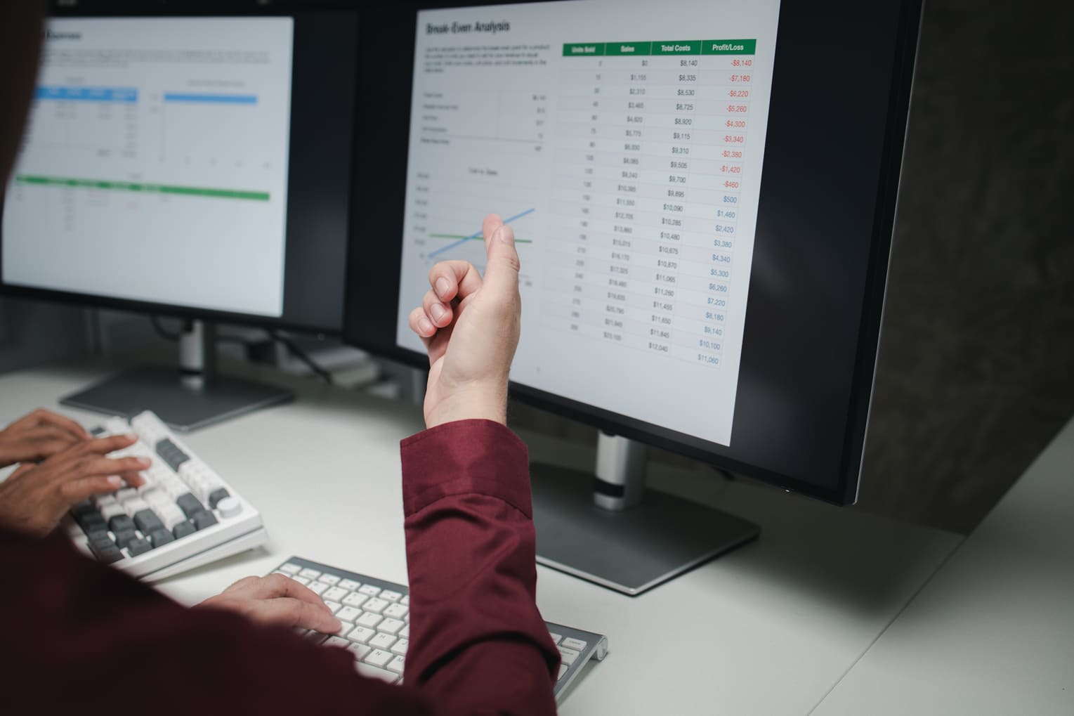 Payroll administrator calculating salary numbers and social insurance contributions on a computer screen.