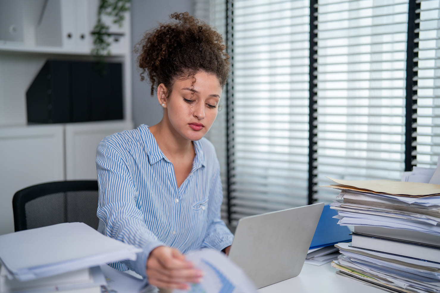 Foreign worker organizing personal documentation and employment records in an office setting.