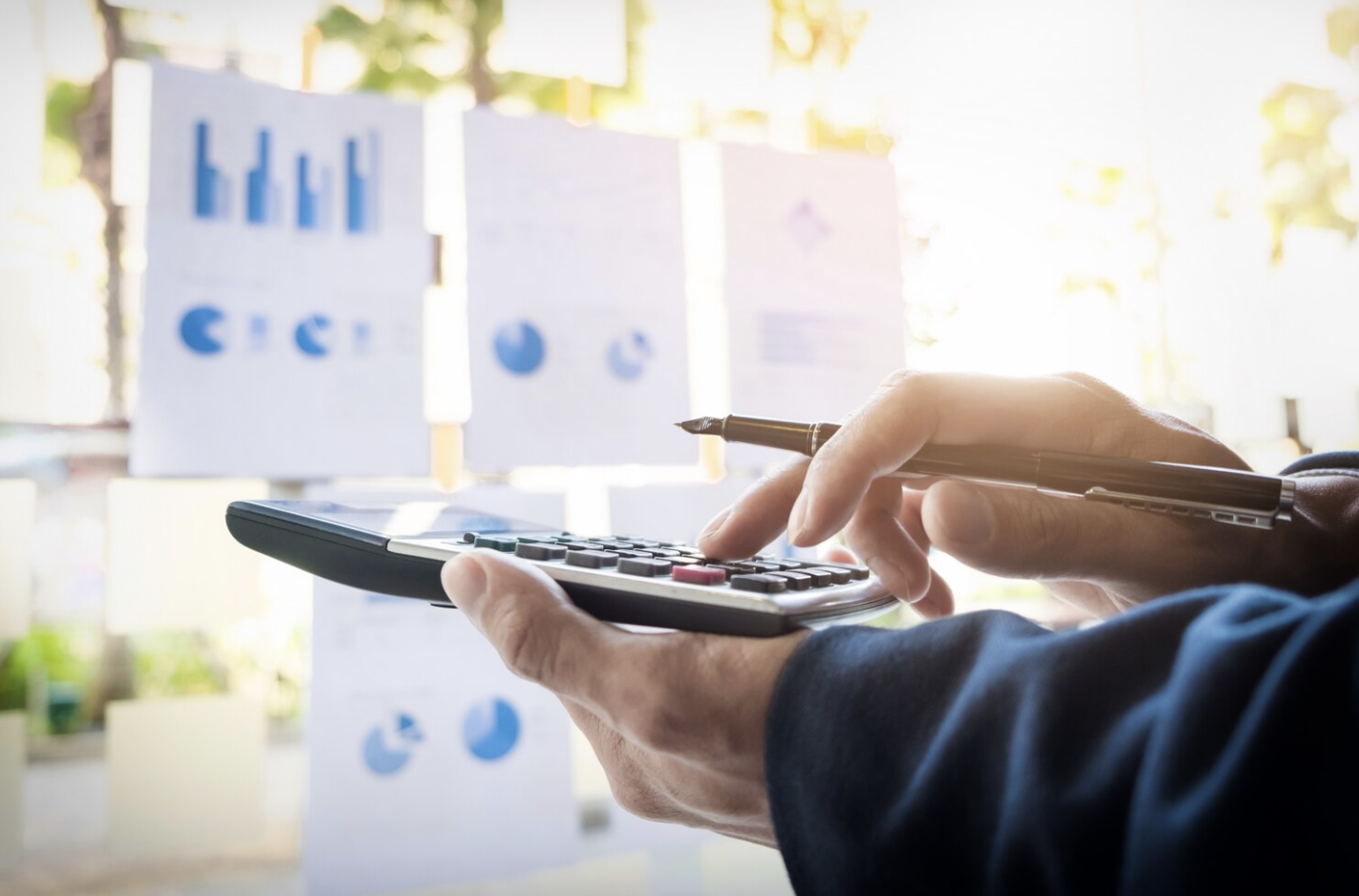 Hình ảnh minh họa dịch vụ payroll outsourcing với chuyên viên tính toán lương và dữ liệu báo cáo doanh nghiệp.