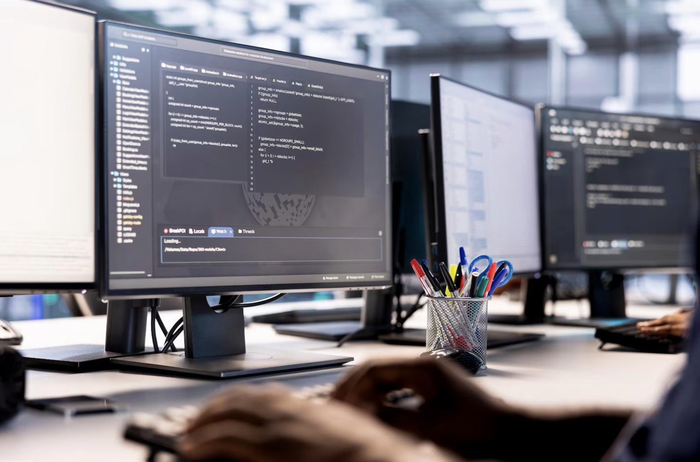 IT professionals working at multiple computer stations in a modern office.